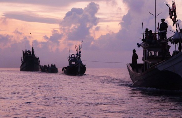 TOPSHOTS
Acehnese fishermen (R in boats) tow a boat of Rohingya migrants in their boat (L) off the coast near the city of Geulumpang in Indonesia's East Aceh district of Aceh province at dawn before being rescued on May 20, 2015. Hundreds of starving boatpeople were rescued off Indonesia on May 20 as Myanmar for the first time offered to help ease a regional migrant crisis blamed in part on its treatment of the ethnic Rohingya minority.    