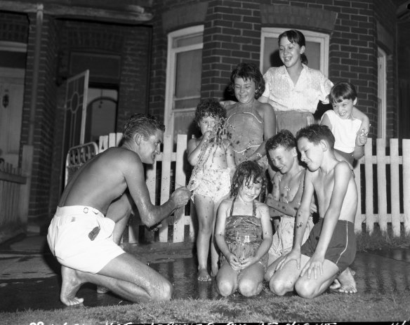 "Mr Jim Joyce of Victoria Street, Alexandria, gives neighbouring children a welcome shower with his garden hose late last night". January 27, 1960