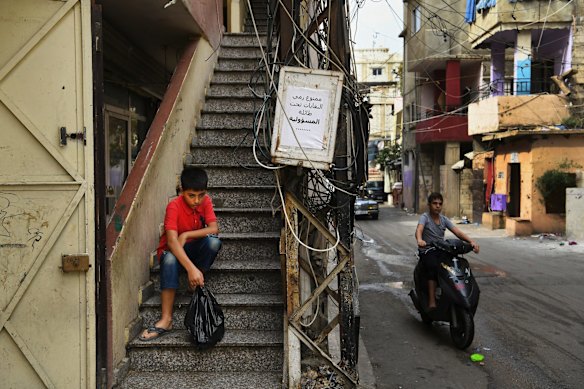 Mohammad al-Deraai, 13 (right) holding the bag of soap he must sell on the streets in Ain al-Hilweh a Palestinian refugee camp in Sidon, Lebanon.  The al-Deraai family are from  Maarrat al-Nuâman in Idlib, Syria and fled to Lebanon. The family have been refused UNHCR assistance so Mohammad is supporting the family by selling soaps and socks on the street in Ain al-Hilweh camp.
