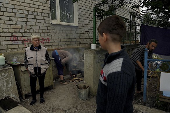 Residents of an apartment building in Siversk cook over wood fires outside the entrance to the basement where they have been seeking shelter from Russian attacks. Without water and power, Siversk has been constantly shelled in recent weeks and many of the residents have fled elsewhere. Siversk, Ukraine. 