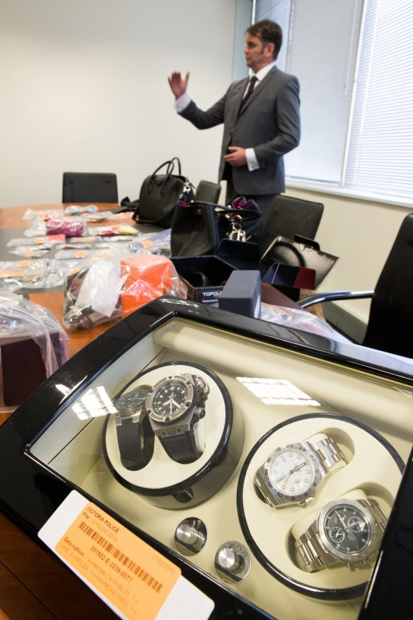  Detective Sergeant Nathan Kaeser with some of the millions of dollars worth of jewellery and bags recovered from under Di Miao's home.