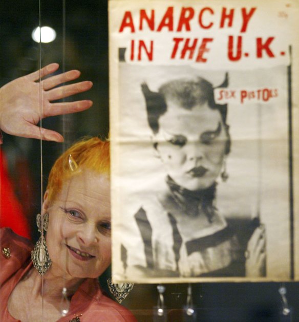 Vivienne Westwood looks through the glass toward the media during a photocall to celebrate her 30 years in the fashion industry, at a retrospective exhibition at the Victoria and Albert Museum in London, Tuesday March 30, 2004. 
