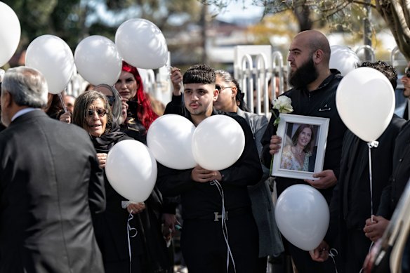 Mourners carry white balloons at Lametta Fudlallah's funeral.