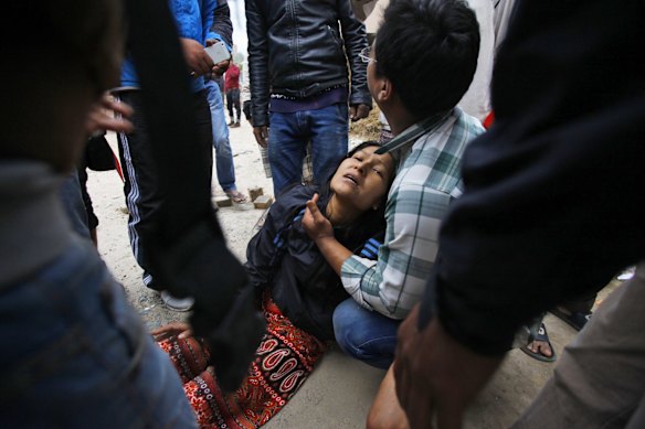 A woman cries as her son remains trapped in the debris of a building that collapsed in an earthquake in Kathmandu, Nepal.
