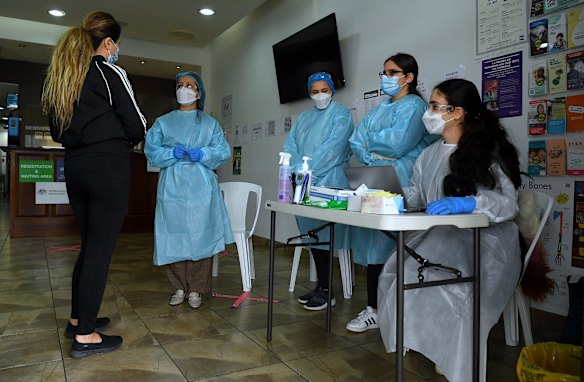 Health care workers talk to a woman at the St Joseph medical centre which is carrying out COVID-19 vaccinations in Fairfield.