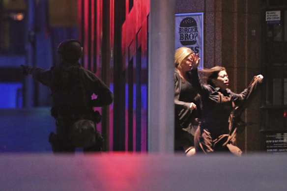 Lindt Chocolat Cafe Siege timeline: 2:03am - Two of six hostages who escaped run from the building towards Special Operations Police in Martin Place.