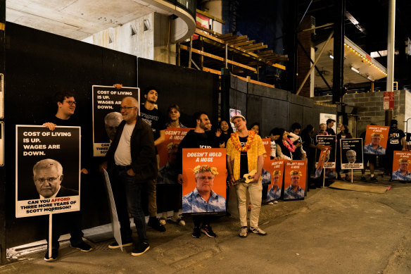 Protesters holding signs attacking Prime Minister Scott Morrison await the leaders outside the headquarters of Nine and The Sydney Morning Herald.