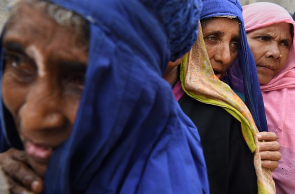 Rohingya refugees queue for a meal provided by a Turkish aid agency at a food distribution site in Shofiullah Kata Camp in the Moynargona area.