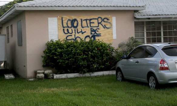 A homeowner in Dania Beach, Florida, has a stern warning painted on his boarded up window.