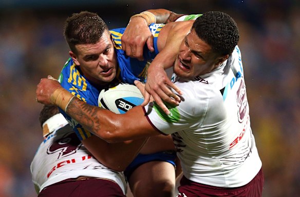 Darcy Lussick of the Eels is tackled by Willie Mason of Manly.