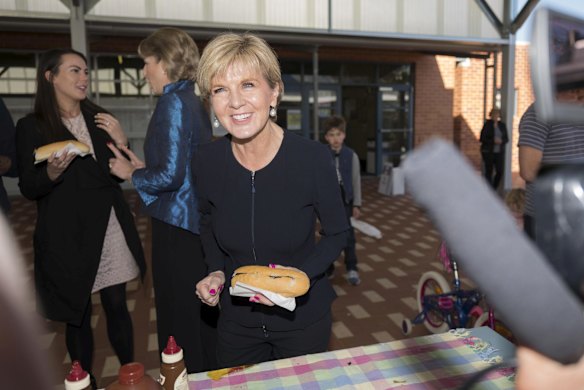 Julie Bishop buys a sausage at the Swanbourne Primary school polling place in Western Australia.