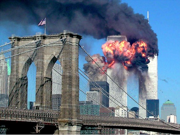 A plane explodes after hitting the second tower of the World Trade Center as the other tower burns in New York September 11, 2001 with the Brooklyn bridge in the foreground.