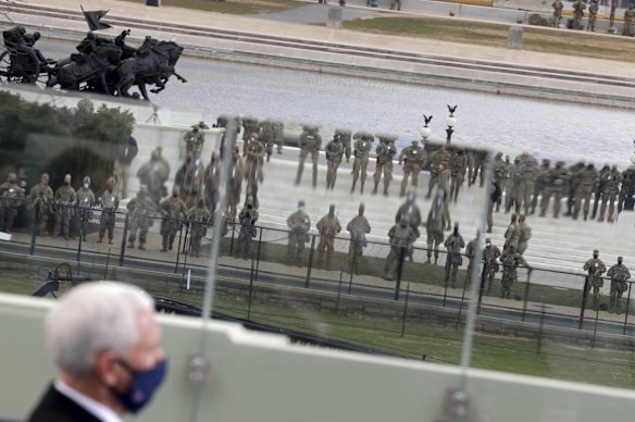 Security personnel are reflected in glass as Vice President Mike Pence attends President-elect Joe Biden's inauguration ceremony, Wednesday, Jan. 20, 2021, in Washington. 