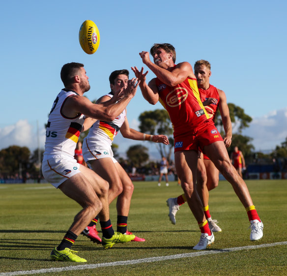 Gold Coast's David Swallow handpasses the ball over to Brad Crouch.