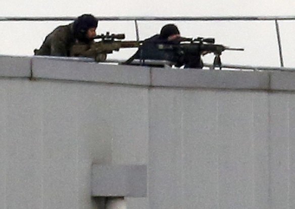 Before the assault ... French special forces take position with sniper rifles on the rooftop of a complex at an industrial building in Dammartin-en-Goele, northeast of Paris.