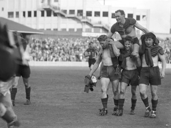 Jack Rayner is carried off by teammates on September 18, 1954