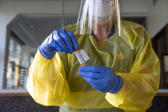 Nurse Rachael Macfarlane carefully handles two samples to be taken to Pathology for processing and evaluation.