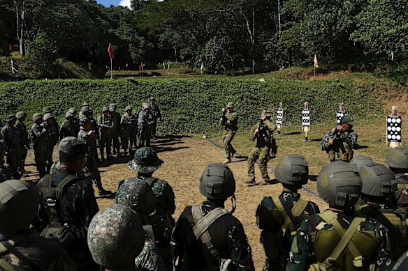 Private Daniel Martin (centre left) and Private Brodie Smith (centre) with the 8th/9th Royal Australian Regiment and Land Mobile Training Team demonstrate firing skills during training at the firing range.
