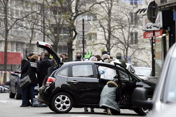 Forensics investigators work on the car used by armed gunmen who stormed the offices of Charlie Hebdo.