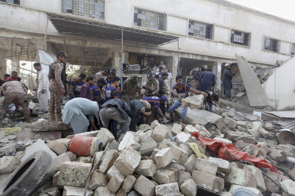 Pakistani security personnel and rescuers inspect the scene of a gas explosion in Karachi.