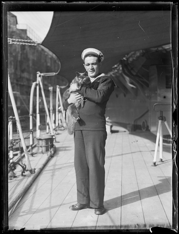 A naval sailor holding a cat onboard HMS Hood, NSW, circa 1934.