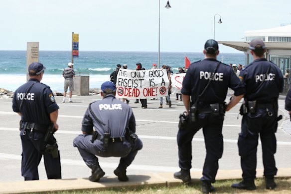 Police watch an anti-racism rally march along the beach in Cronulla.