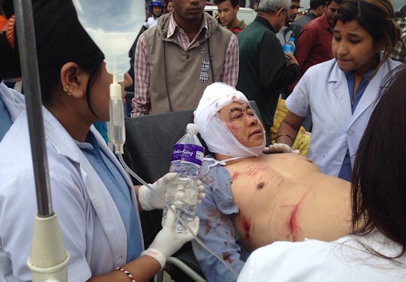 An injured person receives treatment outside the Medicare Hospital in Kathmandu, Nepal.
