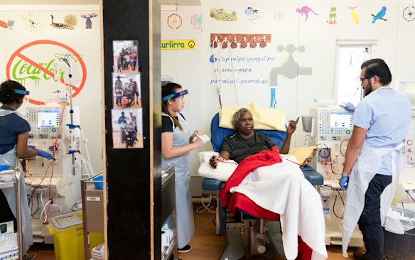 Ormay Gallagher talks with husband and wife nursing team, Justin Chaves and Harris Lidason, as she has dialysis in the remote aboriginal community of Yuendumu.
