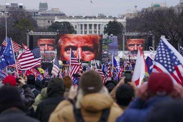 The face of President Donald Trump appears on large screens as supporters participate in a rally in Washington. The House committee investigating the violent January 6 Capitol insurrection, with its latest round of subpoenas in September 2021, may uncover the degree to which Trump, his campaign and the White House were involved in planning the rally that preceded the riot.