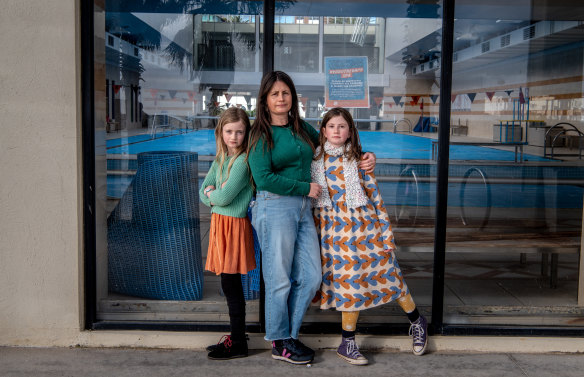 Kathryn Bowen and her daughters Isidora, 8 and Mathilde, 11, outside the St Kilda Sea Baths, where they have swimming lessons when public pools are open. 