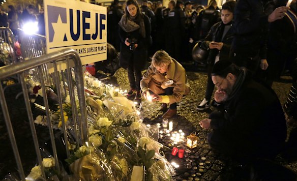 People place candles on January 10, 2015 during a demonstration at the end of Shabbat called by the Jewish Student's Union of France (UEJF) at the Porte de Vincennes in eastern Paris in homage to the four victims of the January 9 nearby hostage-taking drama at a kosher supermarket that ended with a police assault and the killing of the hostage-taker. Hundreds of thousands of people staged rallies across France on January 10 following three days of terror and twin siege dramas that claimed 17 victims, including 12 at the French satirical newspaper Charlie Hebdo in Paris on January 7.