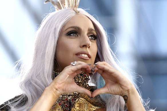 Lady Gaga makes a heart sign to the crowd.