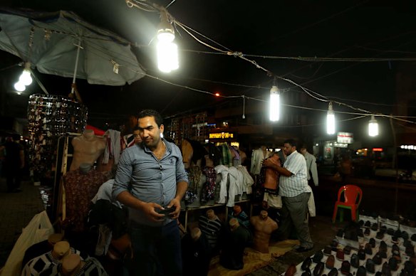 Akeel Banyan 28 (left) stands amongst his shoe market on Karada street in Karada area in Baghdad.