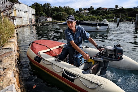 Local Serge Rey starts his dinghy motor at Berry Bay. There are fears that a new harbour tunnel may dredge up toxic material from the floor of the bay.