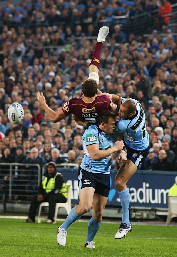 Corey Oates of the Maroons goes up for a high ball next to Josh Morris and Blake Ferguson of the Blues.