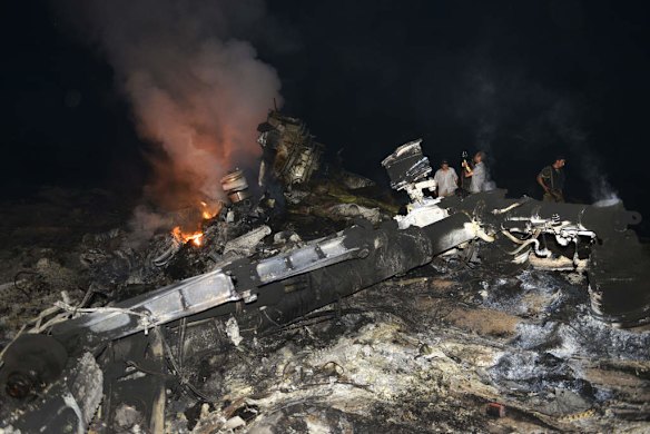 People stand on the wreckage of the malaysian airliner carrying 298 people from Amsterdam to Kuala Lumpur.