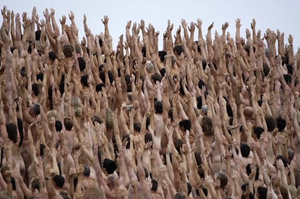  Nude people raise their hands as they gather on the steps of the Sydney Opera House as they pose for a photo by Spencer Tunick.