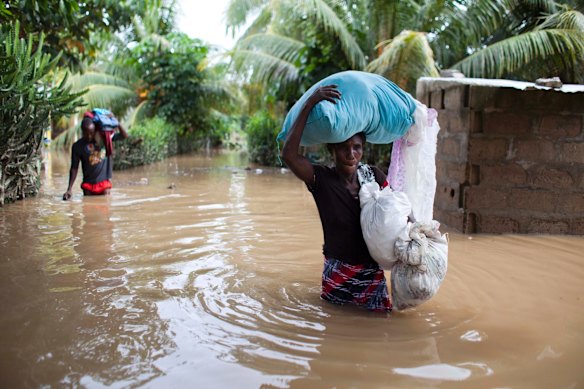 Assilia Joseph, right, and her son Wisner Jean Baptiste, carry the belongings they salvaged from their flooded home after the passing of Hurricane Irma, in Fort-Liberte, Haiti.