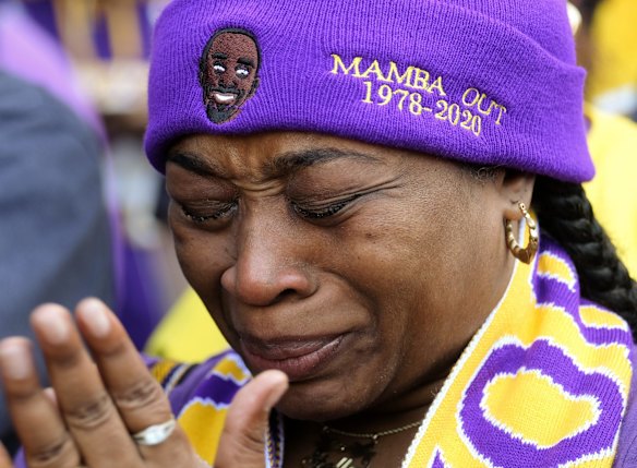 Lioness Saxa cries as she watches the live stream of a public memorial for Kobe Bryant and his daughter, Gianna, outside the Staples Center in Los Angeles.