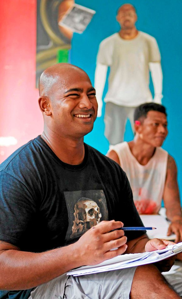 Bali Nine member Myuran Sukumaran smiles as Australian artist Ben Quilty teaches inmates to paint in Kerobokan jail.