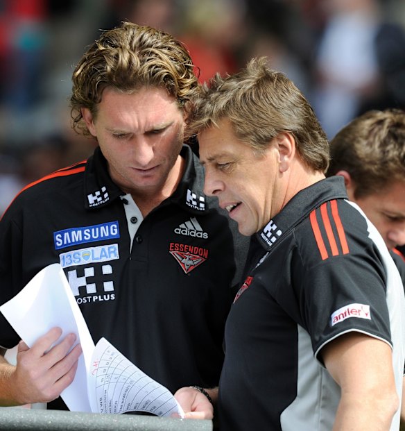 AFL.Round 1 Essendon v Western Bulldogs.Essendon coach James Hird takes advice from Mark Thompson at quarter time. Etihad Stadium,Melbourne 27 March 2011.