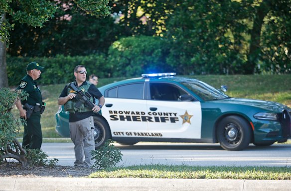 Law enforcement officers block off a street following a shooting at Marjory Stoneman Douglas High School, Wednesday, Feb. 14, 2018, in Parkland, Fla. (AP Photo/Wilfredo Lee)