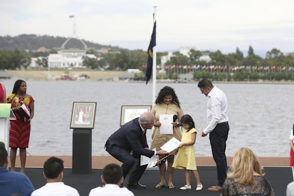 Prime Minister Scott Morrison presents citizenship certificates to the Castaneda family during the flag raising and citizenship ceremony at Rond Terrace in Canberra.