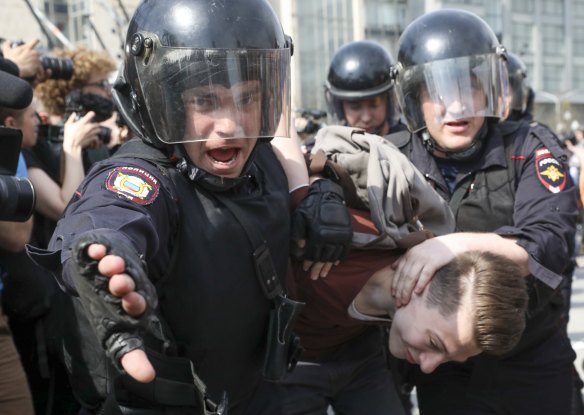 Police detain a protester.