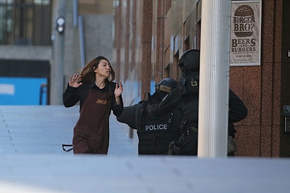 A hostage runs towards police from a the Lindt cafe.