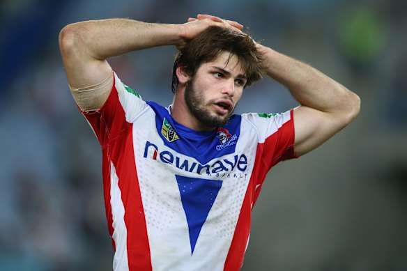 Headache: Jake Mamo of the Knights looks a forlorn figure during the 50-point hiding to the Rabbitohs.