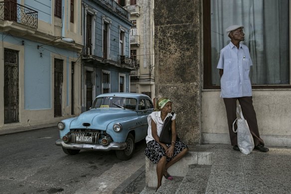 Residents wait for a bus near the Gran Teatro de La Habana Alicia Alonso, where President Barack Obama is scheduled to speak during his official visit to Cuba.