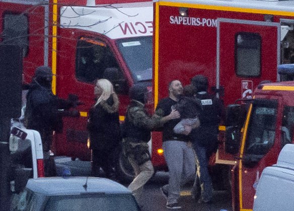 A security officer directs released hostages after they stormed a kosher market to end a hostage situation, Paris.