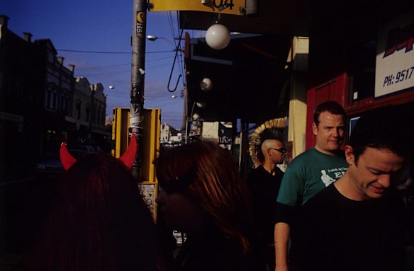 A girl in devils horns checks the bus timetable on Enmore Road during The Under The Blue Moon / Goth Fest, Newtown.