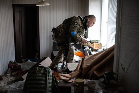 Yurii, 41, who serves in the Ukrainian military, grabs a wedding photograph from his trashed apartment, which was taken over by Russian troops during their occupation of Hostomel.